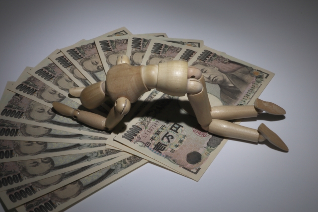 お金とうなだれる人形