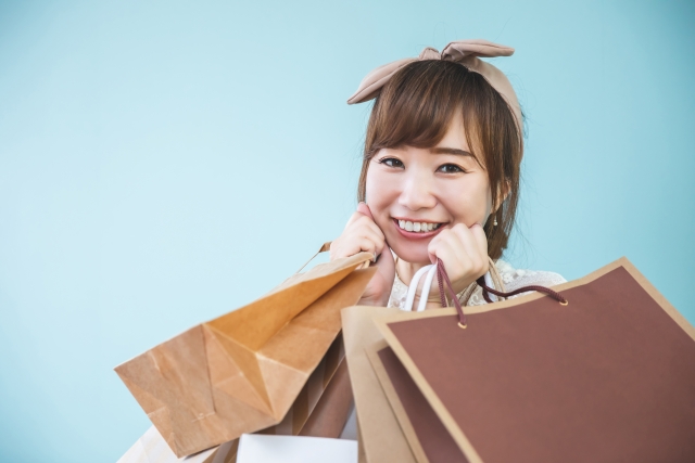 ショッピングバックを大量に持つ女性